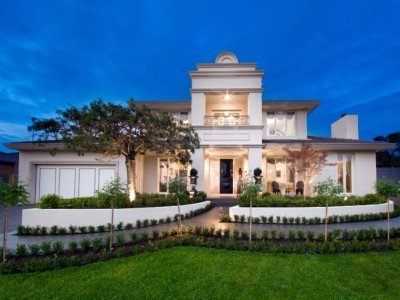 a large white house with a lawn and trees in front of it