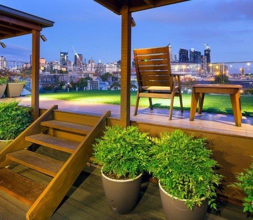 a deck with a table and chairs and a view of a city