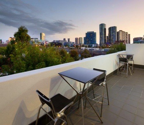 a deck with chairs and a view of a city