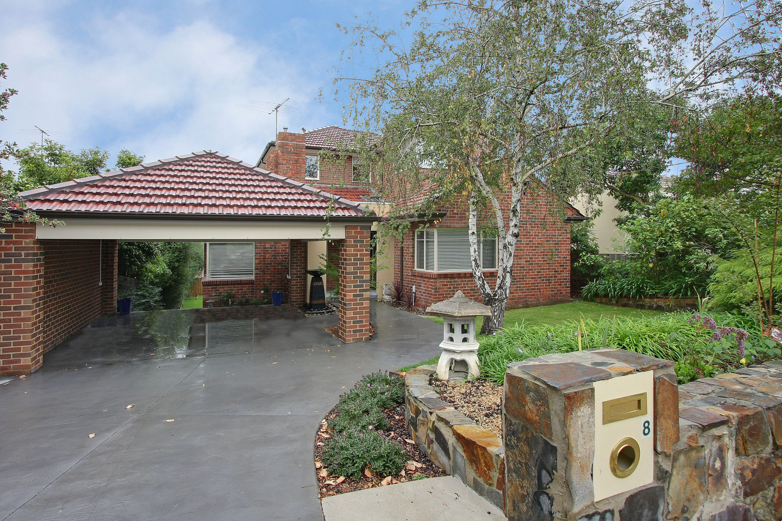 a brick house with a brick driveway