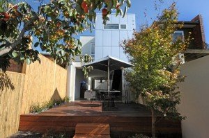 a deck with a table and chairs and a building in the background