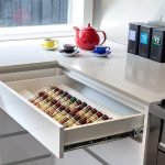 a kitchen counter with a tray of food and teapots