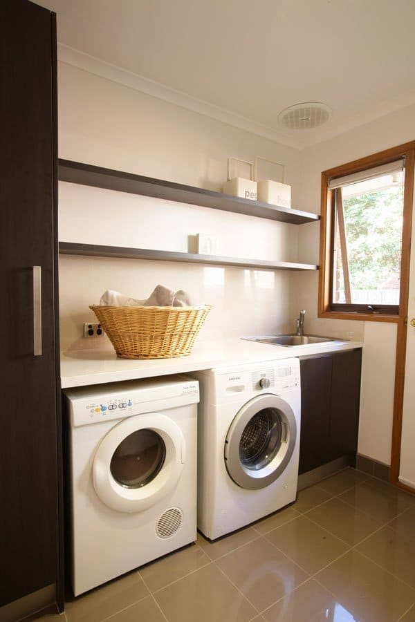 Laundry cabinetry with integrated appliances and timber shelves