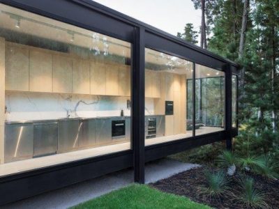 Kitchen with glass walls surrounded by forest