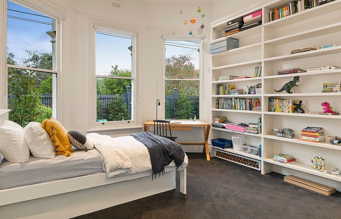 a bedroom with a bed and bookshelves