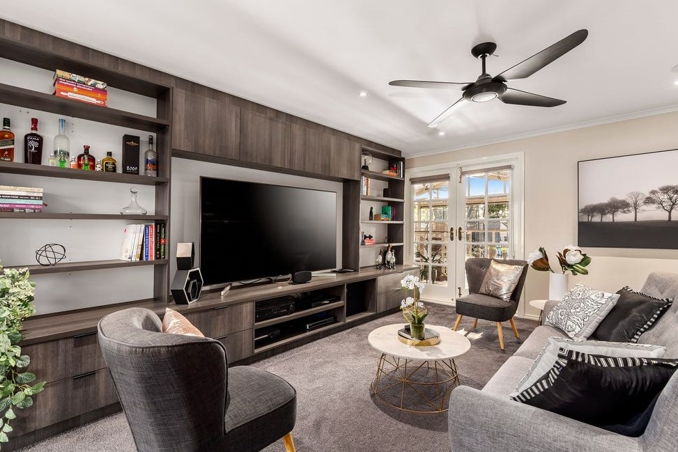 a living room with a tv and shelves