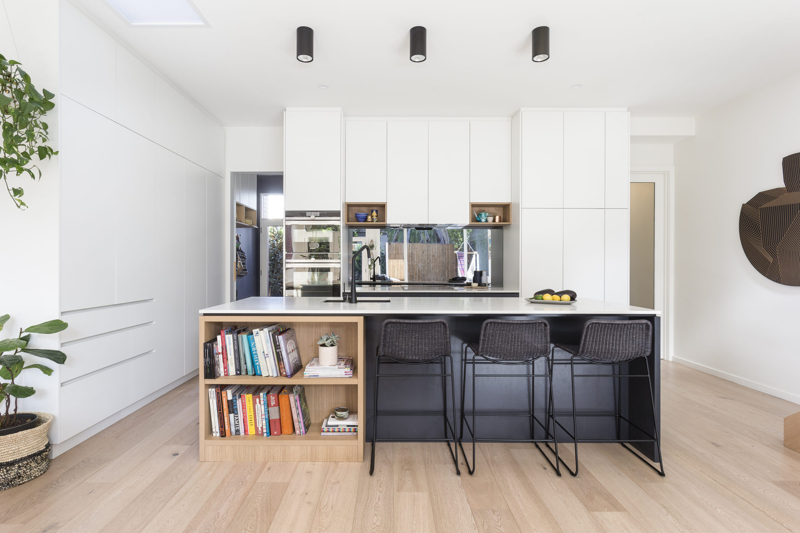 a kitchen with a book shelf and chairs