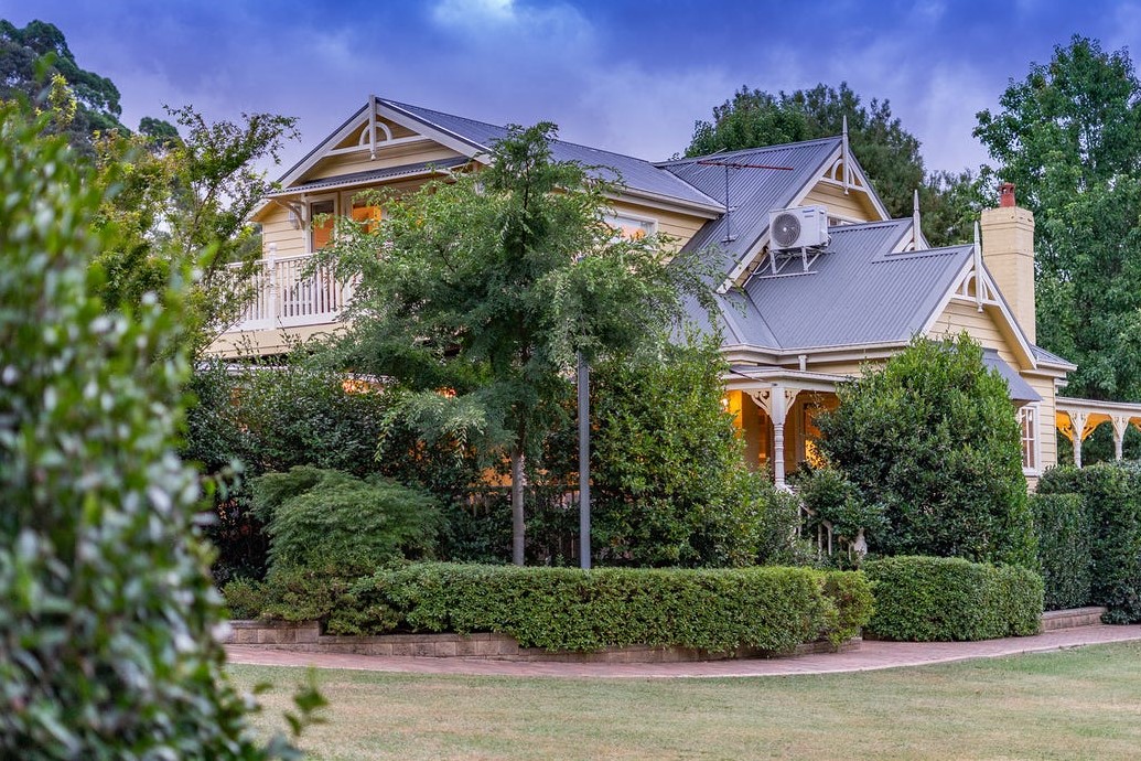 a house with trees and bushes in front of it