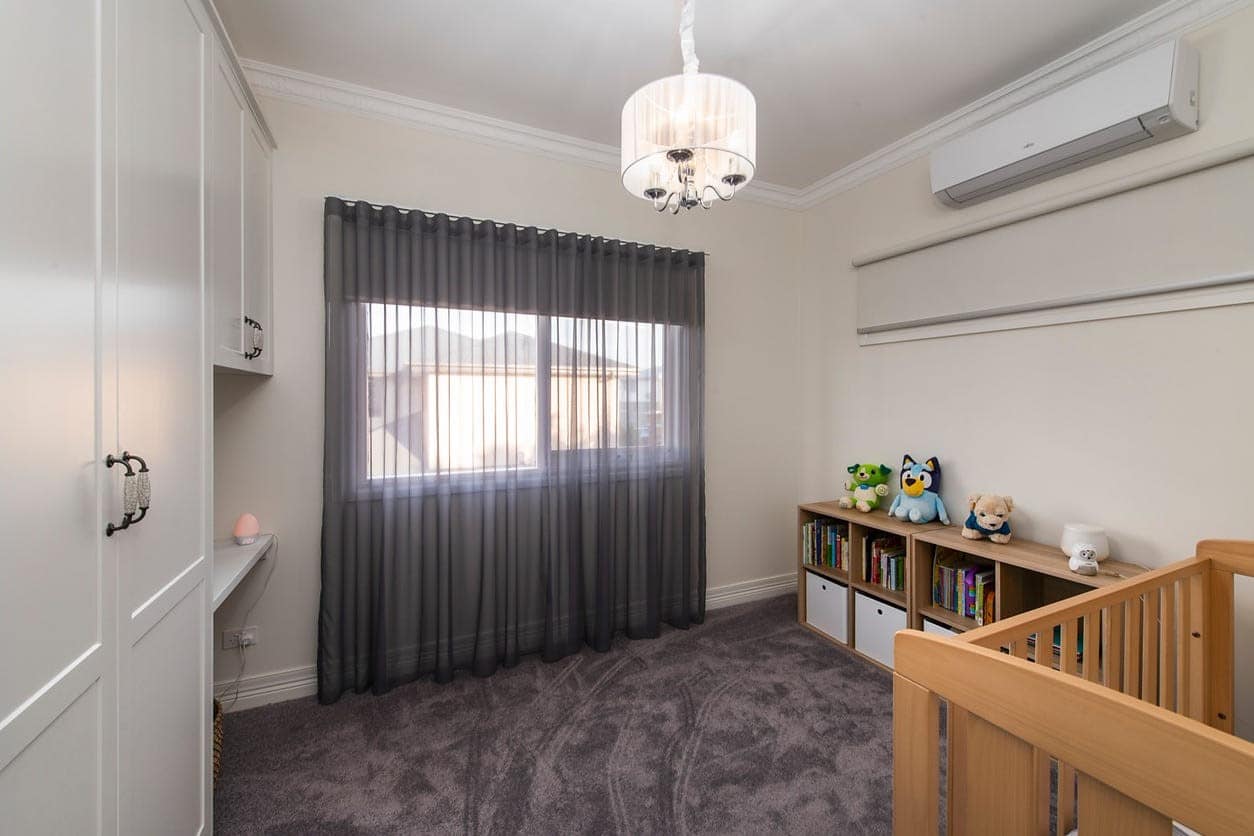 a room with a window and a shelf with a bookcase