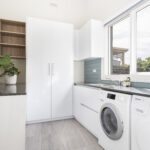a white kitchen with a washer and dryer
