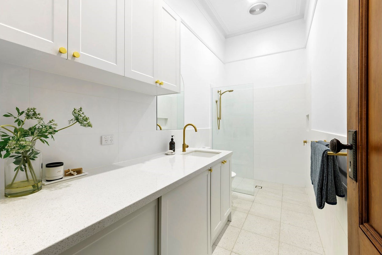 a bathroom with white cabinets