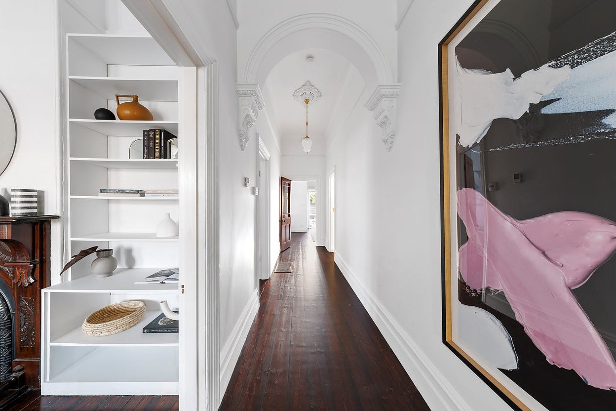 a hallway with a shelf and a bookcase