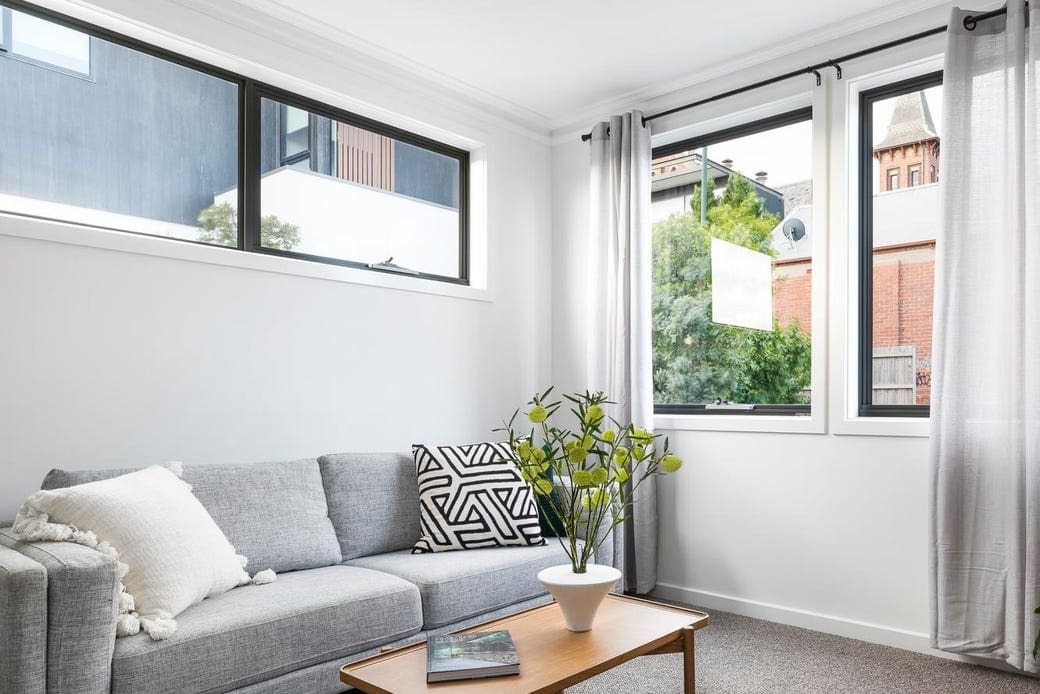 a living room with a couch and a table with a plant