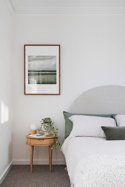 a bed with a table and a plant on it