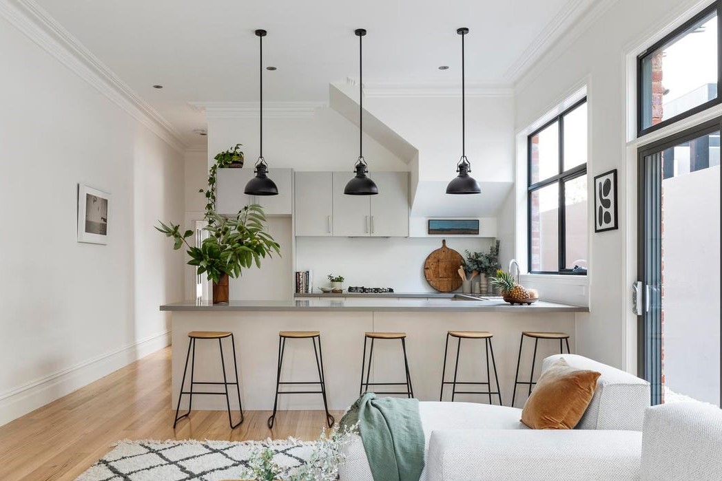 a kitchen with a bar stool and a white couch