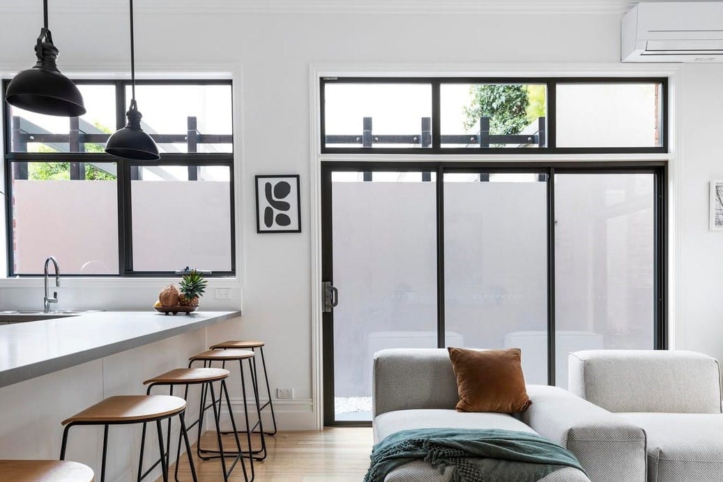 a room with a couch and a table with a chair and a window