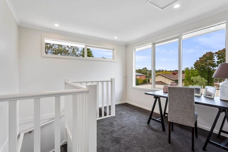 a room with a desk and chairs