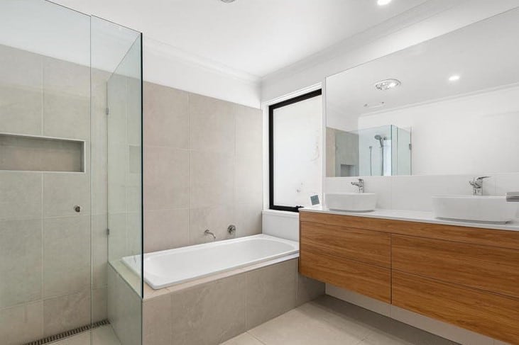 a bathroom with a tub sink and mirror