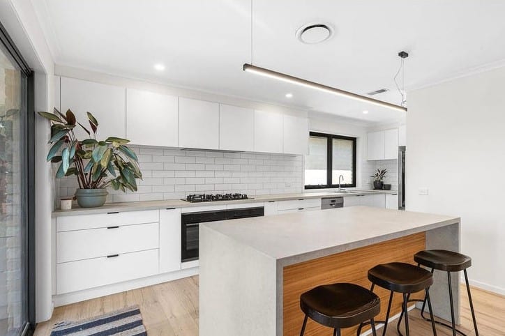 a kitchen with stools and a plant